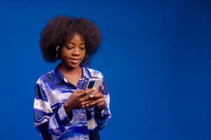 young african lady isolated over pink background using her phone photo