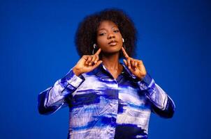 Gorgeous lady listening music in headphones and singing on blue background. photo