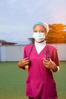 covid-19 pandemic. confident modern physician woman in scrubs with stethoscope, medical mask photo