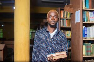 close up of a handsome male reading books in the library photo