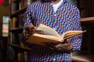 close of a guy in the library reading for exam photo