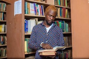 joven hombre elegir libro en público biblioteca foto