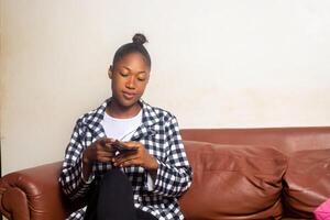 African American woman counting money in living room photo