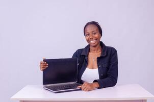 portrait of a beautiful young black woman showing her laptop screen photo