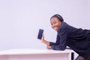 smiling beautiful young black woman showing her phone screen photo