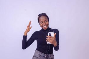 Young woman using phone for listening to music on white background photo