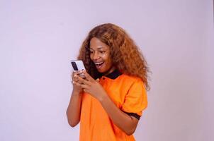 young black woman using her phone looking surprised photo