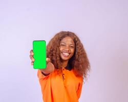 beautiful black girl shows her phone screen while feeling happy and excited, advertising concept, focus on her face photo