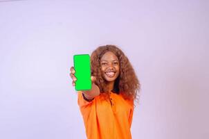 beautiful black girl shows her phone screen while feeling happy and excited, advertising concept, focus on her face photo