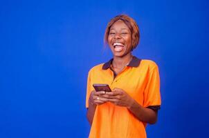 overjoyed young black woman using her phone looking amazed photo