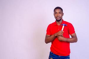 close up of a handsome african man isolated over white background holding hammer photo