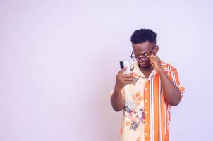 Cheerful African American man in white shirt using mobile phone application. photo