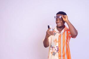 Cheerful African American man in white shirt using mobile phone application. photo