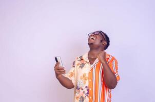 excited African American man in white shirt using mobile phone application. photo