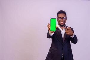 excited young black business man showing his phone screen to the camera and pointing to it photo