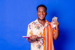 happy and excited young african man holding bundles of cash photo