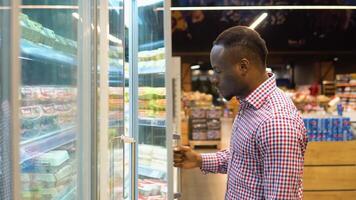 African american man chooses chicken eggs in a farm food store video