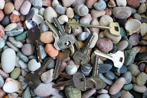 A pattern of different types of keys from locks laid out on stones top view photo