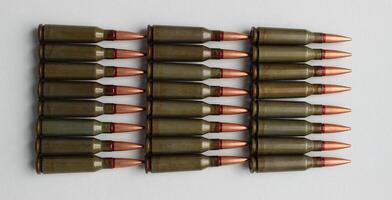 Ammunition for automatic rifle lined up with groups on a white background stock photo