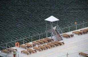 Lifeguard Stand Between Deckchairs At Relax Area Near Pond photo