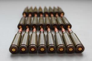 Closeup View Of live ammunition capsules for assault rifle laid out in rows on white background photo