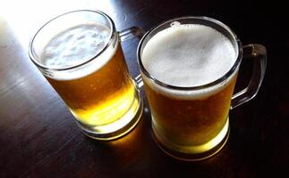 Two glasses of lager beer on the table detailed top view photo