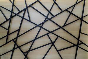 Welded square black iron pipes on a wood panel of reception desk photo