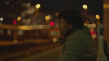 Young Man With Black Curly Hair Waiting Lonely at Train Station at Night video