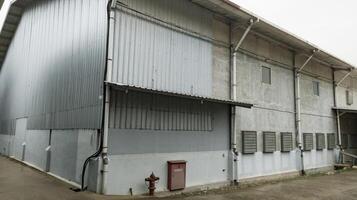 Industrial building with steel roof construction and  installed exhaust fans on the wall, and with hydrant installation. photo