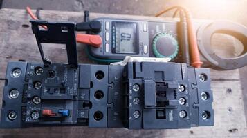 Checking magnetic contactor terminals using a multimeter, magnetic contactor electrical control components. Terminals connection wiring check. photo