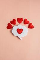 Chat icon with hearts on a light background. Online dating. Online love and acquaintance. Communication via chat. Modern love. Copy space. photo