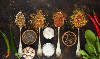 A variety of spices and herbs on a dark table. Cooking background. View from above. Ingredients for cooking. Table background menu. Copy space. photo