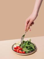 A dish with boiled eggs, strawberries and fresh salad on a beige table. Healthy food. Hard light photo