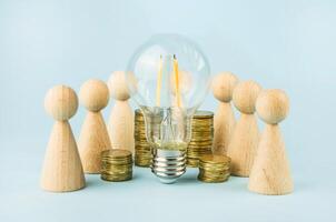 Business concept. Brain storm. Wooden figures of people stand around coins and a lamp. photo