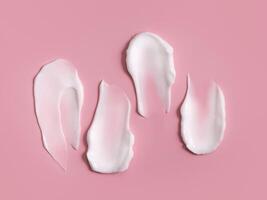 Cosmetic smear, cream texture on a pink background. Skin care. photo