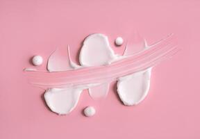 Cosmetic smear, cream texture on a pink background. Skin care. photo