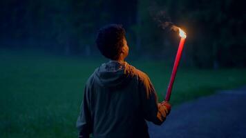 destemido fêmea pessoa segurando flamejante queimando luz da tocha caminhando ao ar livre video