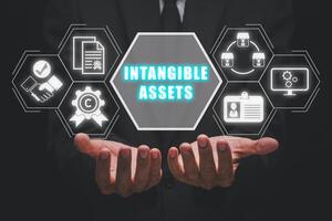 Intangible asset concept, Businessman hands holding intangible asset icon on virtual screen. photo