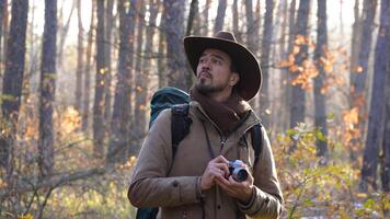 A tourist with a camera travels in the forest. Travel concept photo