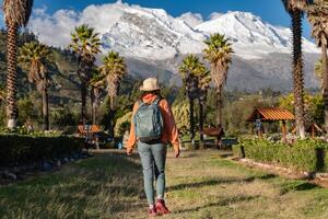 Tourist walks through the town named Yungay with the snow-capped Huascaran in the background. photo
