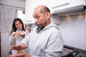 Man having fun with cookie dough prepared at home. photo