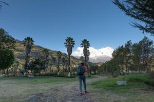 turista camina mediante el pueblo de yungay y en el antecedentes el nevadas huascarán. foto