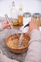 Hands pouring ingredients to make cookies at home. photo