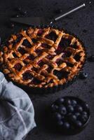 Homemade red fruit and blueberry pie placed on a dark background. photo