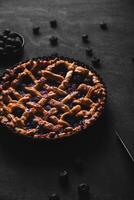 Homemade red fruit and blueberry pie placed on a dark background. photo