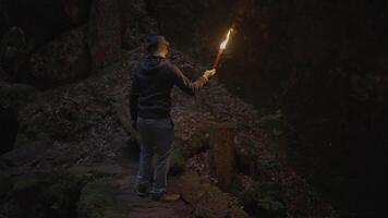 jovem masculino pessoa sozinho em assustador noite aventura com flamejante tocha luz video