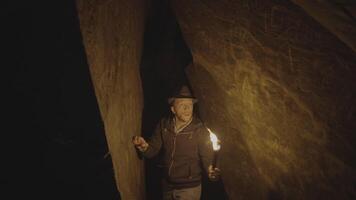 hombre participación un ardiente antorcha explorador bosque cueva paisaje en oscuro noche video