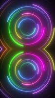 verticaal video - levendig gloeiend neon disco cirkels retro achtergrond. kleurrijk spinnen concentrisch neon cirkels. vol hd beweging achtergrond animatie.