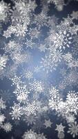 Vertical video - beautiful winter snowflakes and snow particles on blue background. This Winter snow, Christmas motion background animation is a seamless loop.