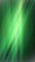 Vertical video - dynamic green background with fast moving waves of textured light. Full HD and looping abstract background animation.